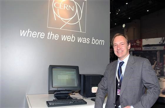 Tim Berners-Lee stands in front of the first web server at Pal expo during the World Summit on the Information Society